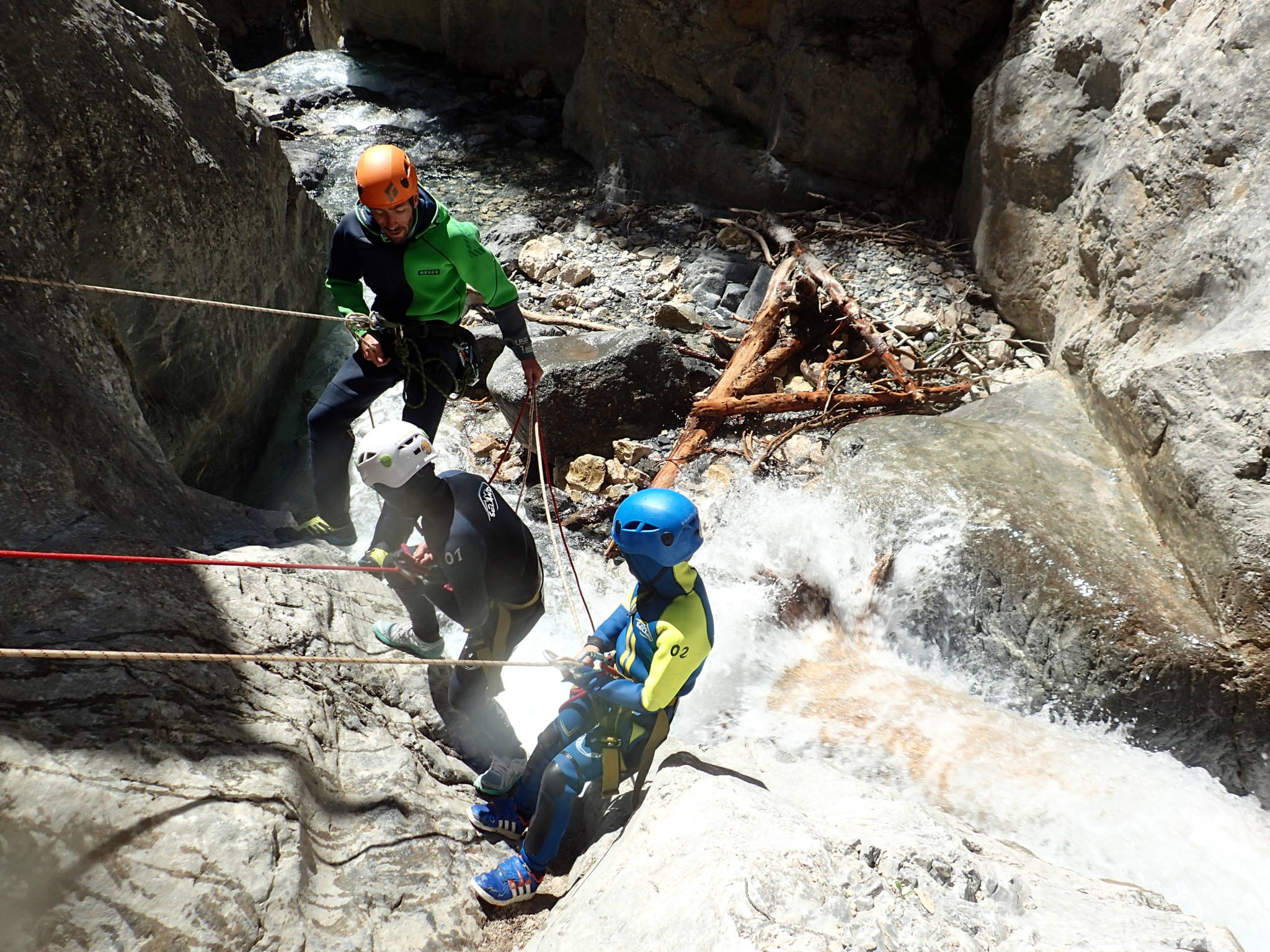 Le guide aide un enfant à descendre en canyoning
