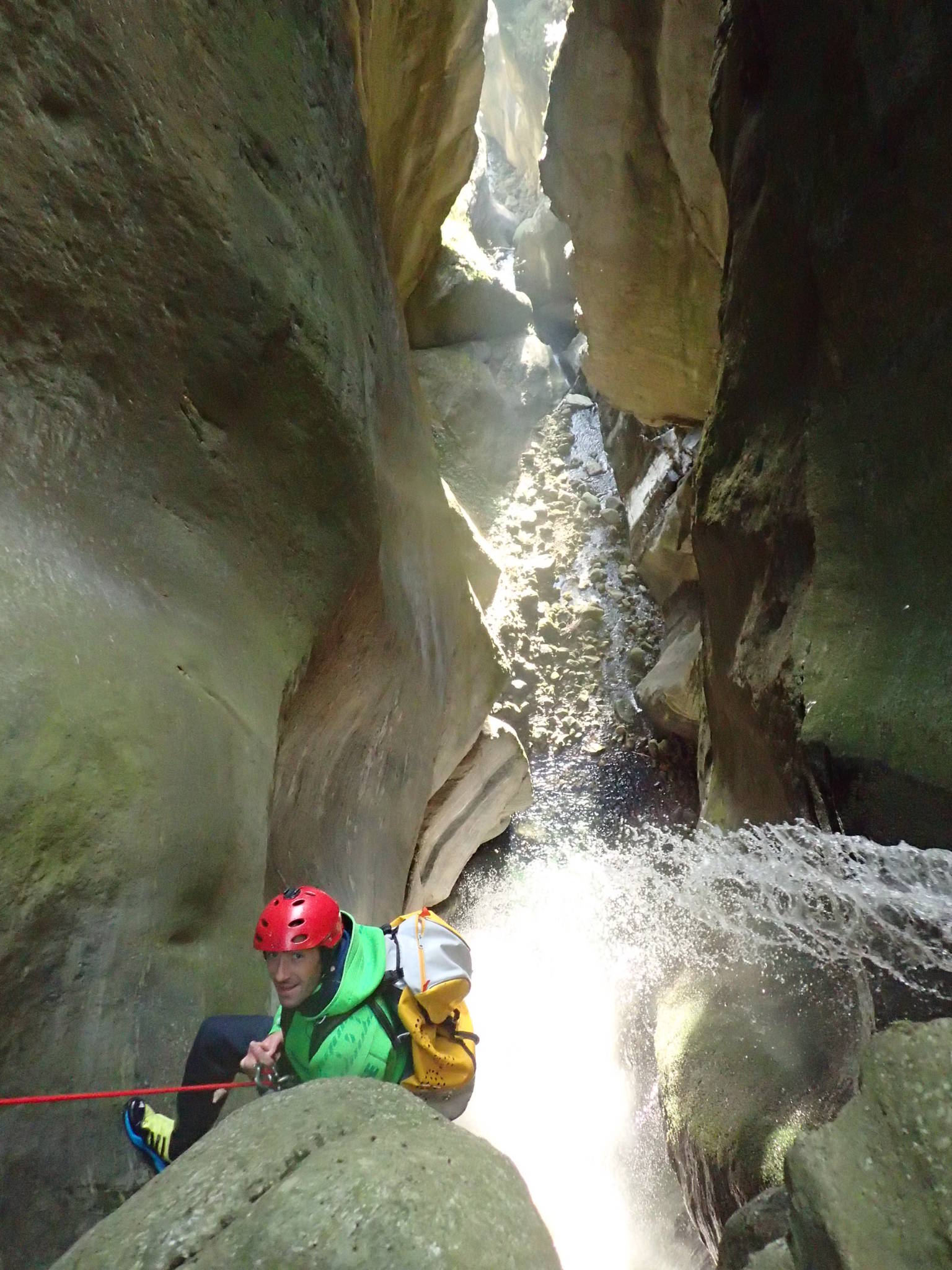 Guide de canyoning qui descend en rappel
